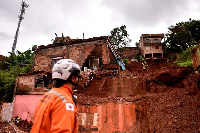 A firefighter looks at the site of a landslide in Belo Horizonte