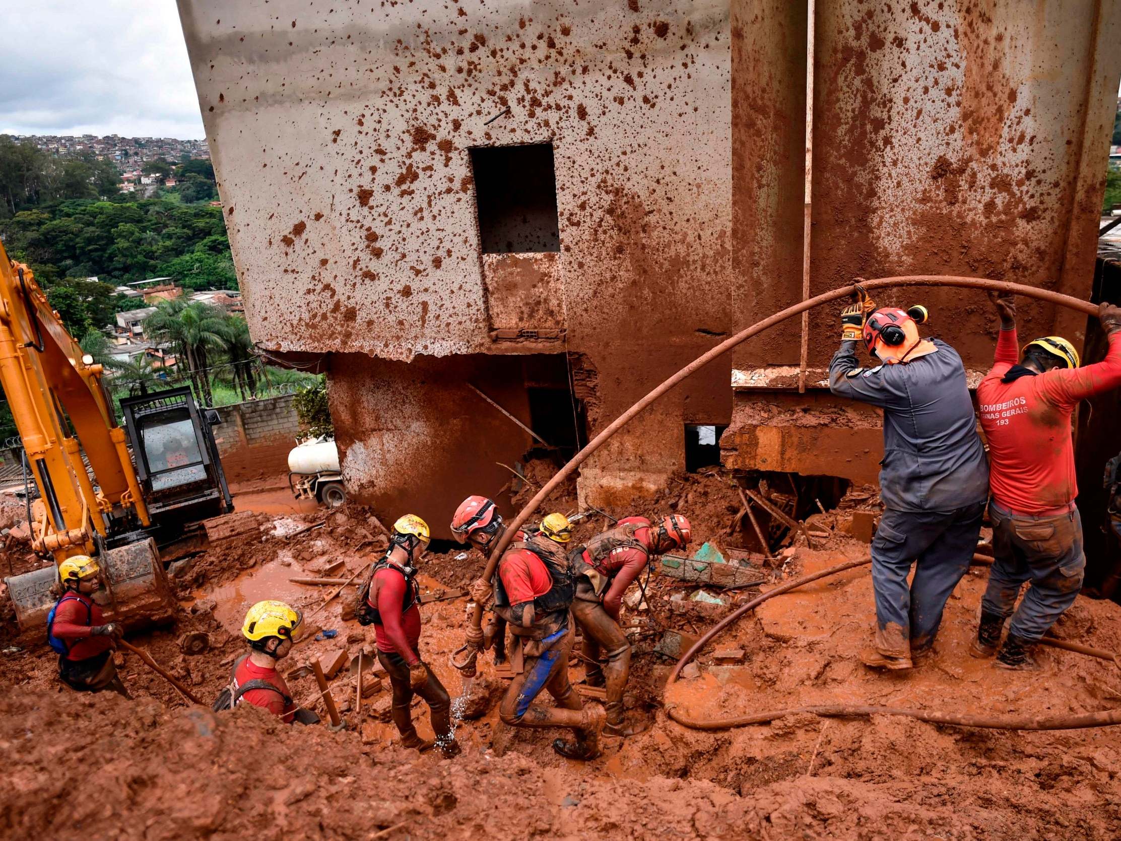 Firefighters search for missing persons using a hydraulic dismantling technique, which uses water to disperse mud, in Belo Horizonte