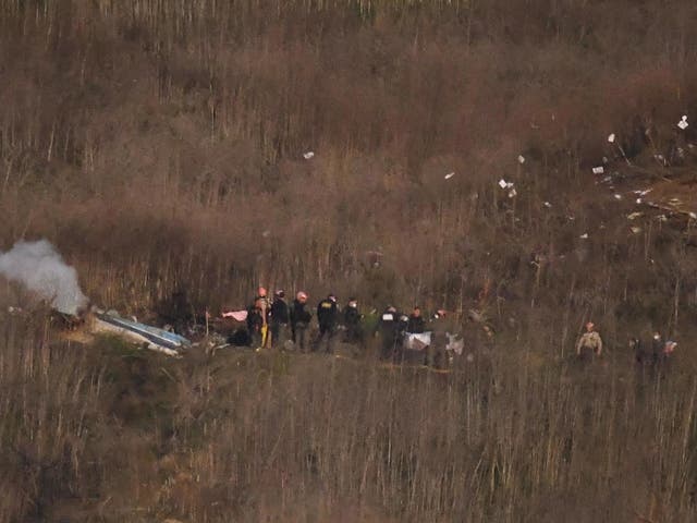 A body is carried from the scene of a helicopter crash that killed former NBA basketball player Kobe Bryant, his daughter and several others