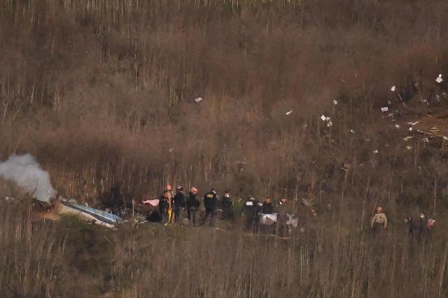 A body is carried from the scene of a helicopter crash that killed former NBA basketball player Kobe Bryant, his daughter and several others