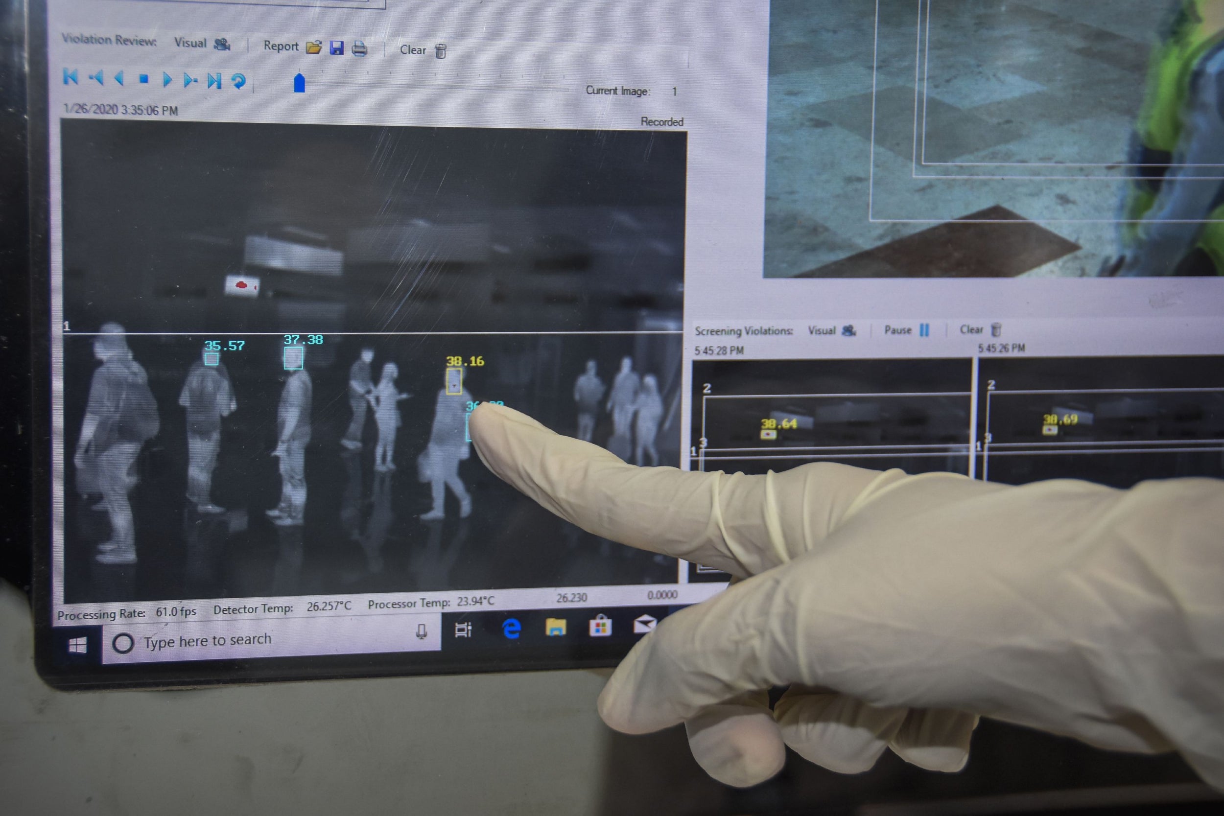 An Indonesian health officer points at the screen of a thermal scanner for passengers