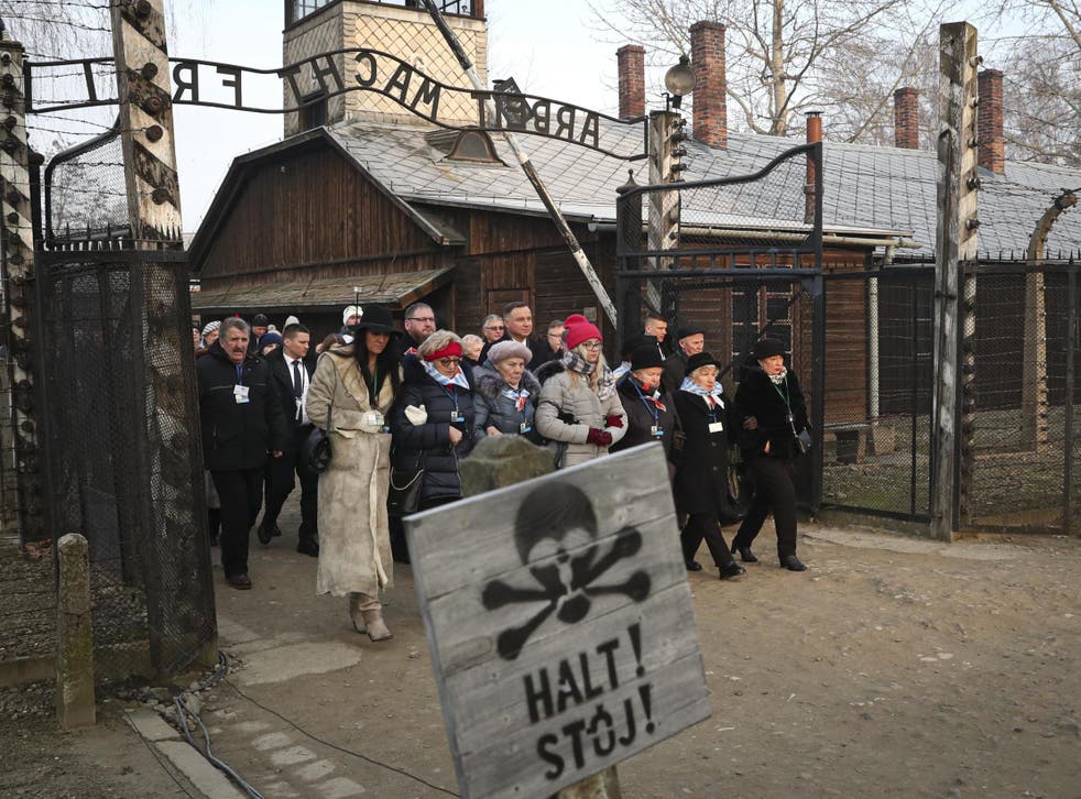 The president of Poland Andrzej Duda walks with survivors through the gates of Auschwitz to attend the 75th anniversary commemorations