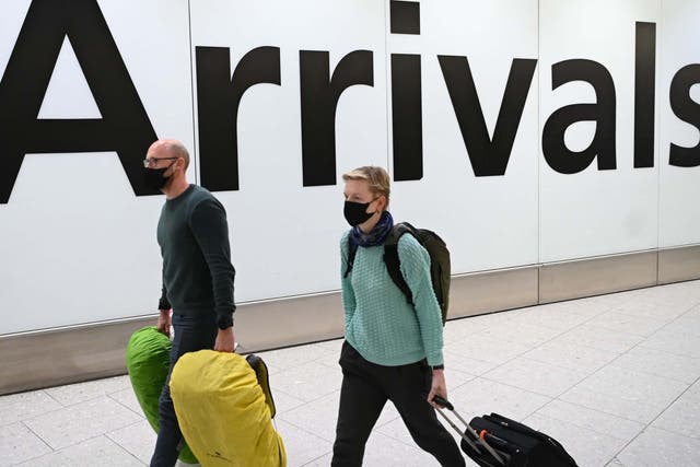 Passengers wear face masks as they arrive at London Heathrow Airport in west London on 28 January, 2020.