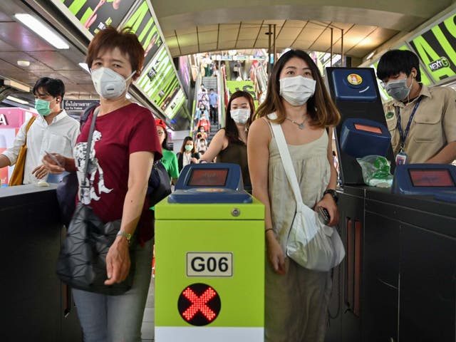 People wear protective facemasks at a commuter train station in Bangkok, Thailand, on 28 January, 2020.