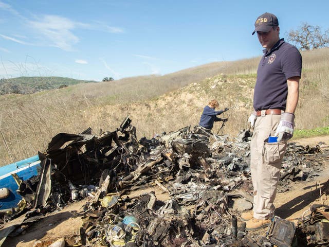 NTSB investigators search through the wreckage of the helicopter that crashed carrying Kobe Bryant and his daughter