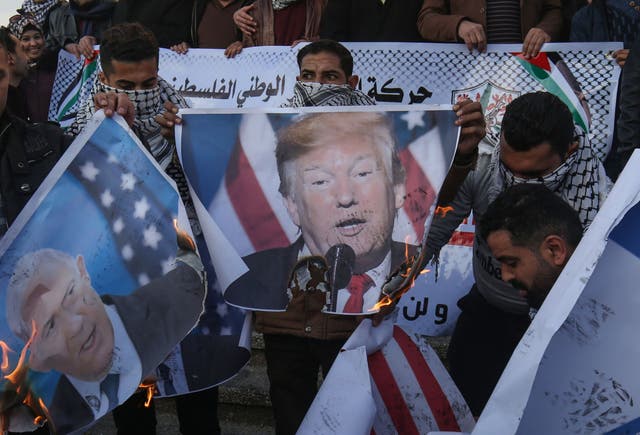 Palestinian demonstrators burn images of US President Donald Trump and Israeli Prime Minister Benjamin Netanyahu during a demonstration in Rafah in the southern Gaza Strip on Wednesday