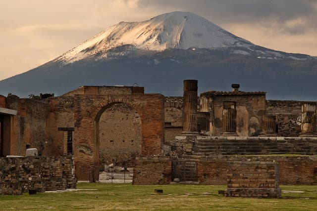 Mount Vesuvius looms over the Temple of Jupiter in the ancient city   