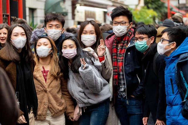 Visitors to China Town in London wearing masks; stocks on some websites have sold out