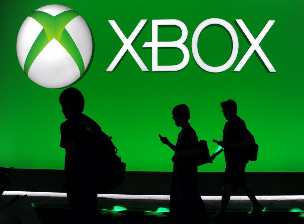 Attendees walk under the Microsoft Xbox One logo on the final day of the E3 Electronic Entertainment Expo, in Los Angeles, California June 13, 2013