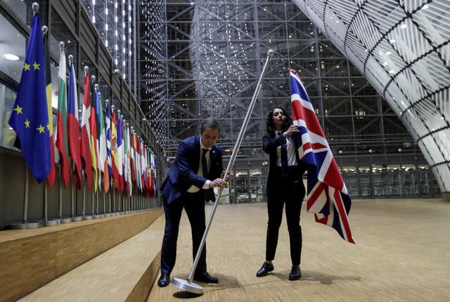 Officials remove the British flag at European Union Council in Brussels