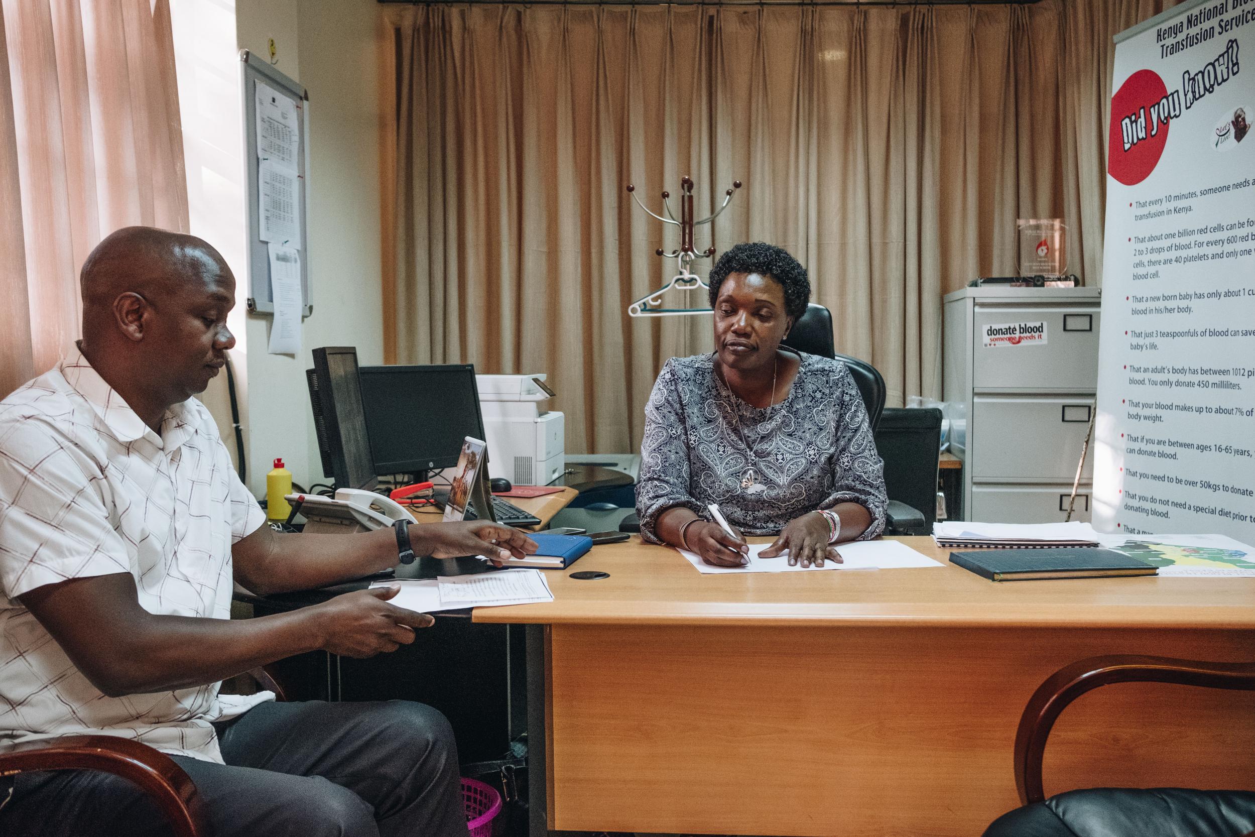 Fridah Govedi, the head of the transfusion service at Kenyatta National Hospital, talks to a colleague(Khadija Farah/The Washington Post)