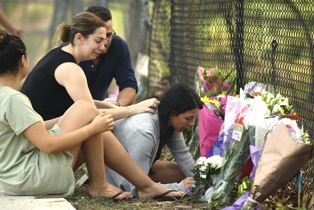 The victims' mother Leila Geagea, right, pauses near flowers placed at the scene where seven children were hit on a footpath by a four-wheel drive in the Sydney