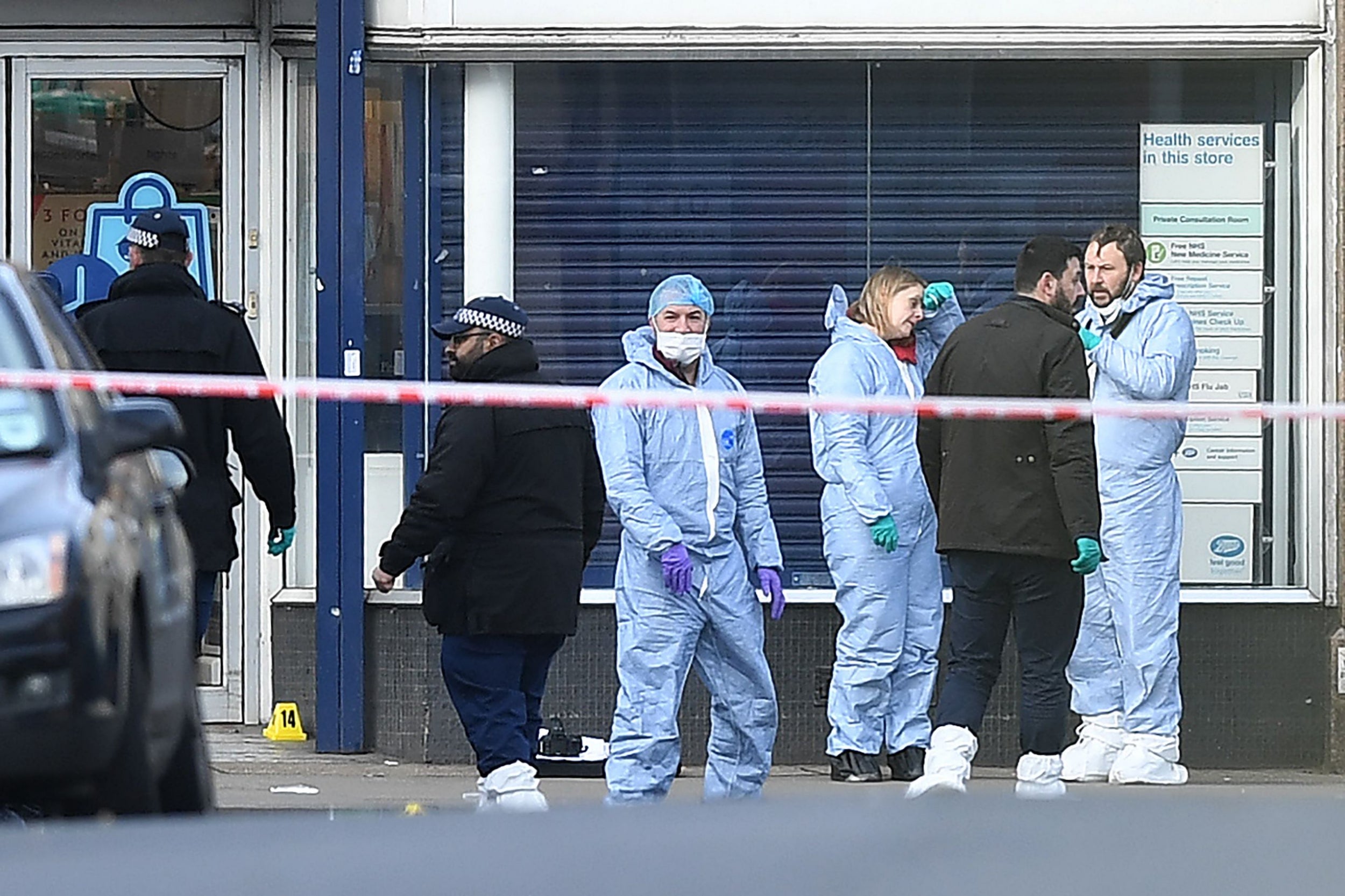Forensic officers work outside a shop on Streatham High Road