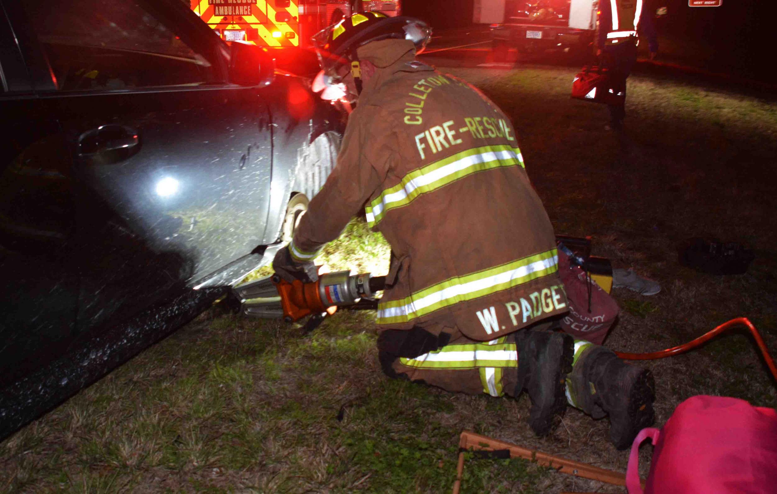 A firefighter uses a hydraulic tool to lift a car after a woman's hands were crushed while changing a tyre on 2 February, 2020, near North Charleston, South Carolina.