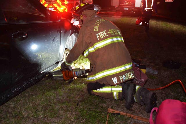 A firefighter uses a hydraulic tool to lift a car after a woman's hands were crushed while changing a tyre on 2 February, 2020, near North Charleston, South Carolina.