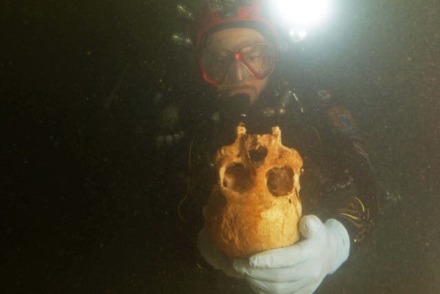 A diver brings up the skull from a 10,000-year-old skeleton found in an underwater cave in Mexico