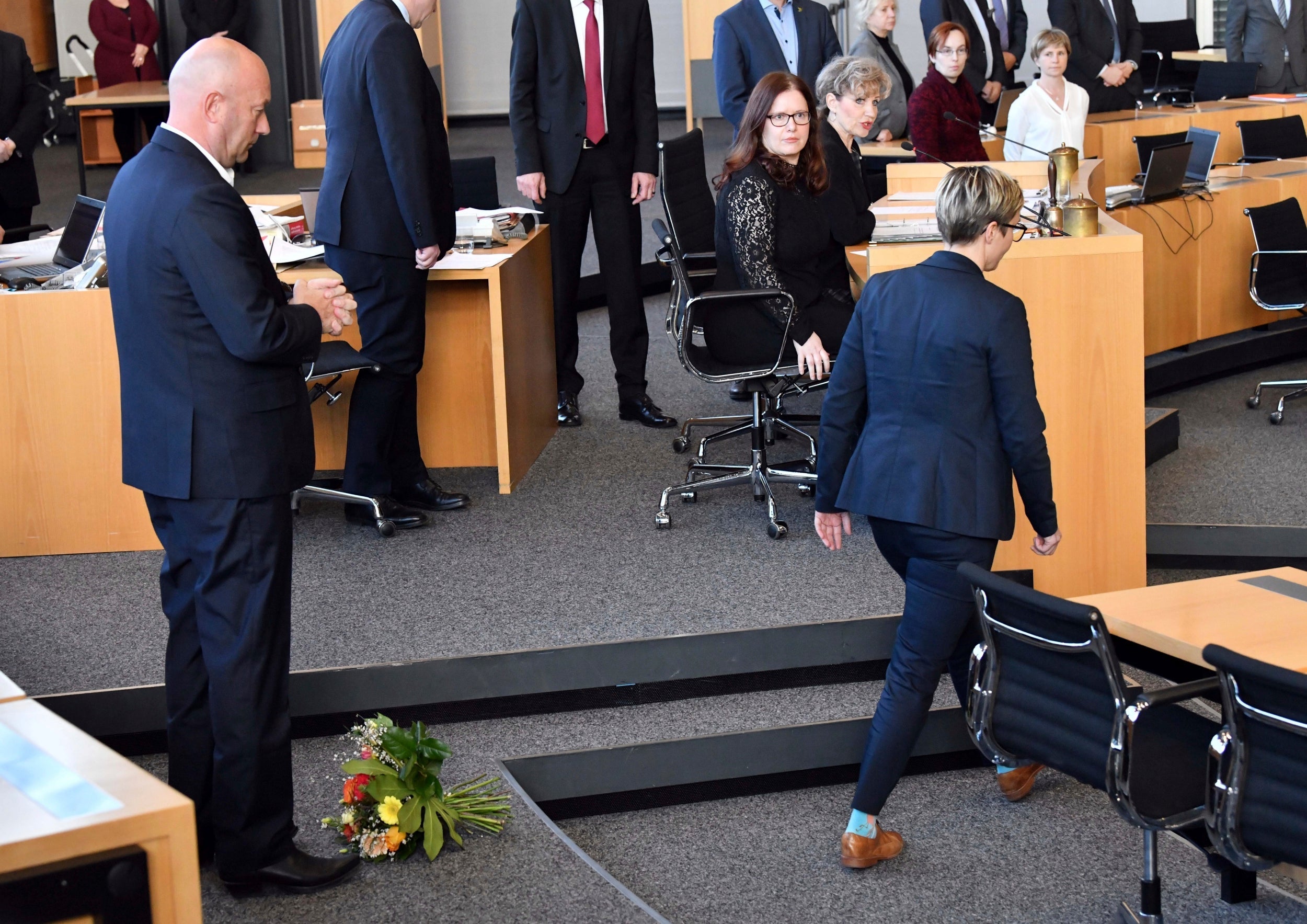 Die Linke's Susanne Hennig-Wellsow, right, walks away from Thomas Kemmerich of the FDP, after throwing a bouquet of flowers in front of him