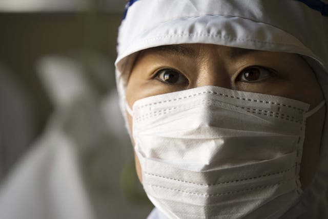 An employee wears a disposable face mask at the Yokoi Co. Ltd. factory in Nagoya, Japan, 6 February, 2020.