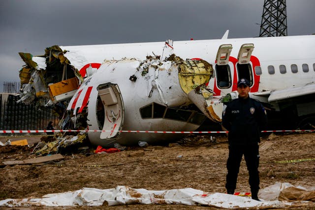 Turkish police guard the wreckage of a plane operated by Pegasus Airlines after it skidded off the runway