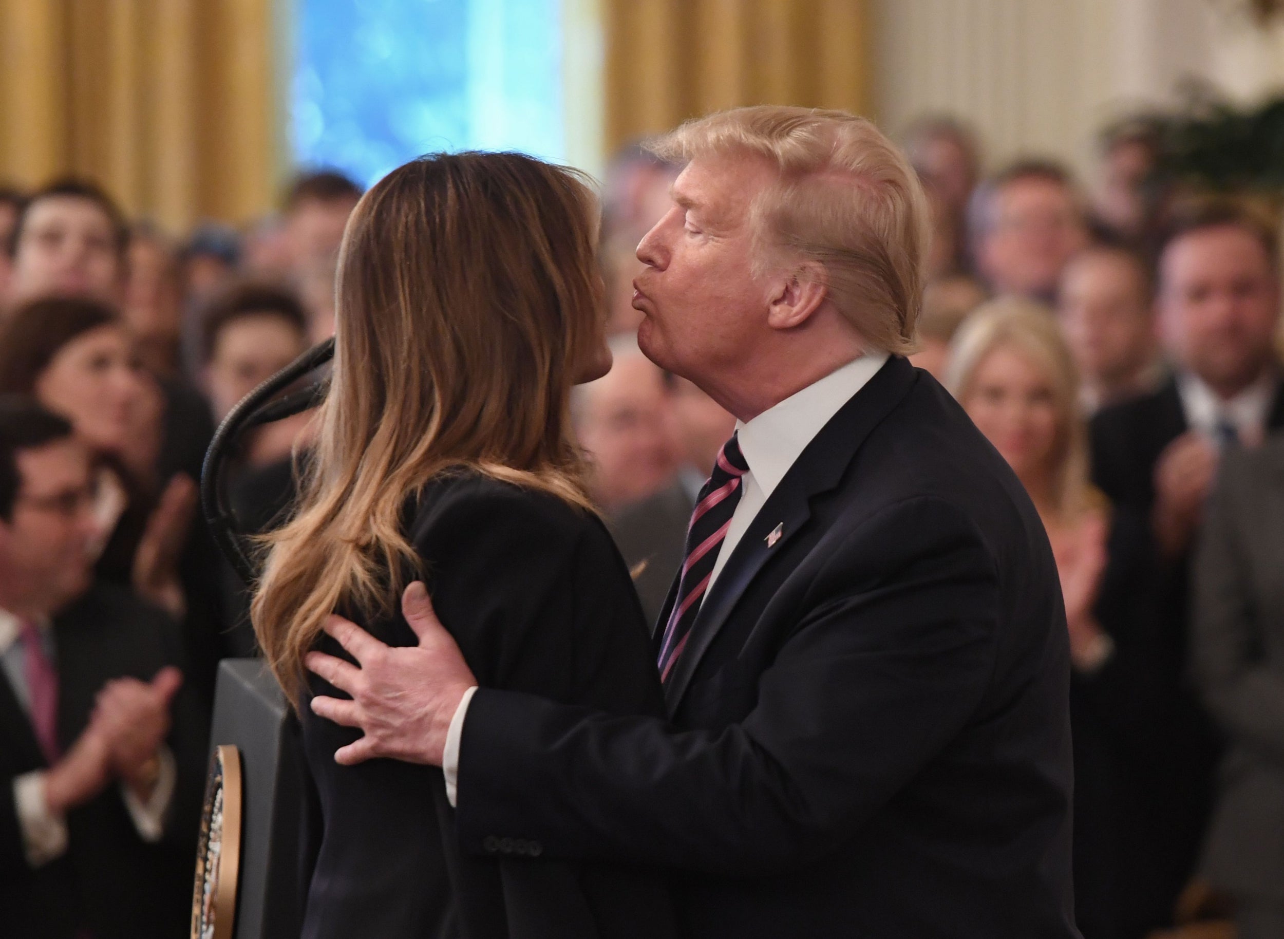 Donald Trump kisses the first lady after giving a speech in front of supporters following his Senate impeachment acquittal