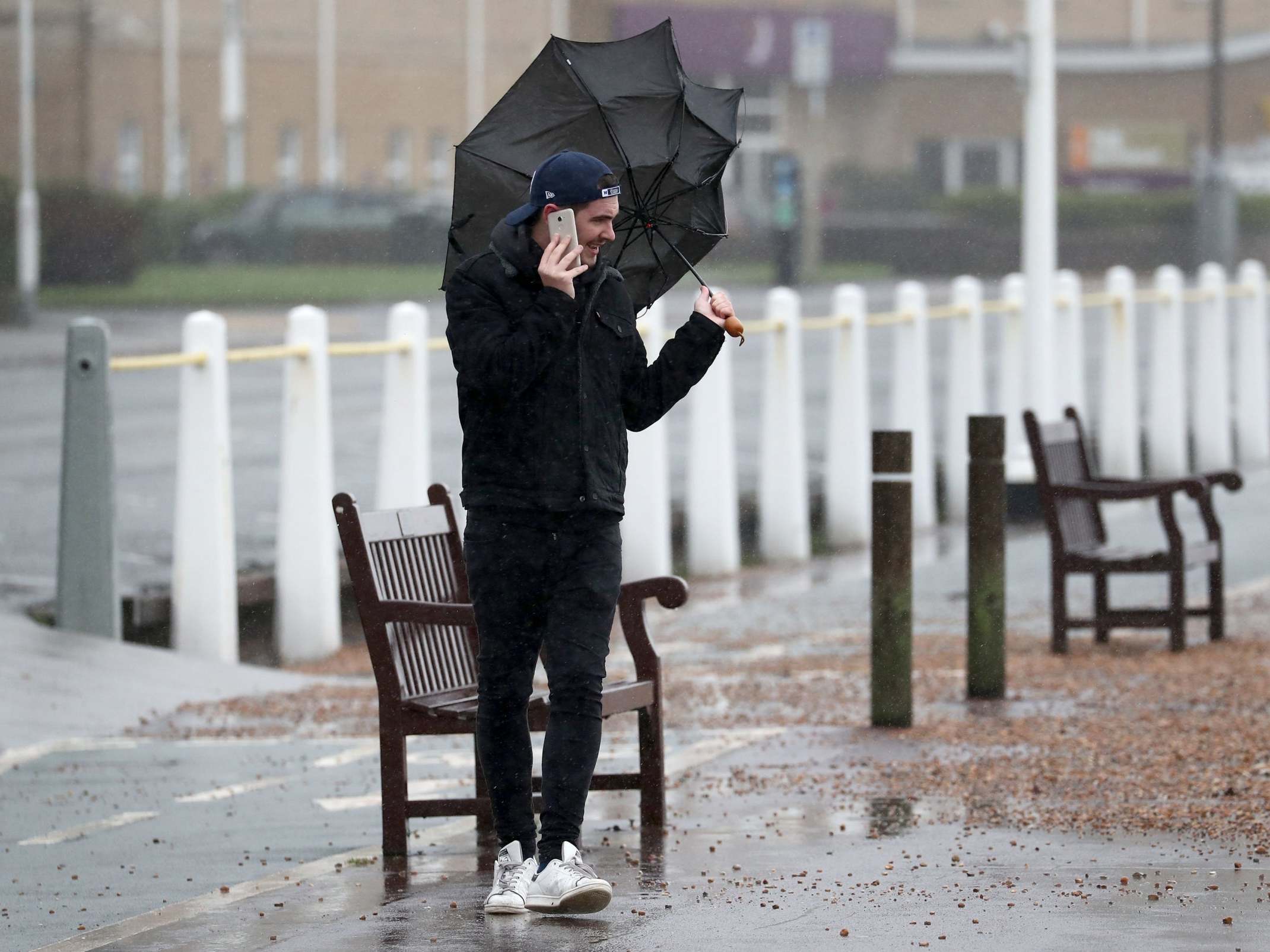 A man walks along the promenade in Dover, Kent, during strong winds and rain