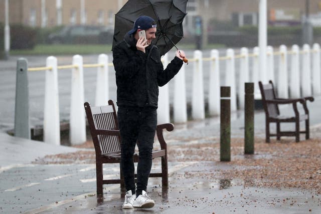A man walks along the promenade in Dover, Kent, during strong winds and rain