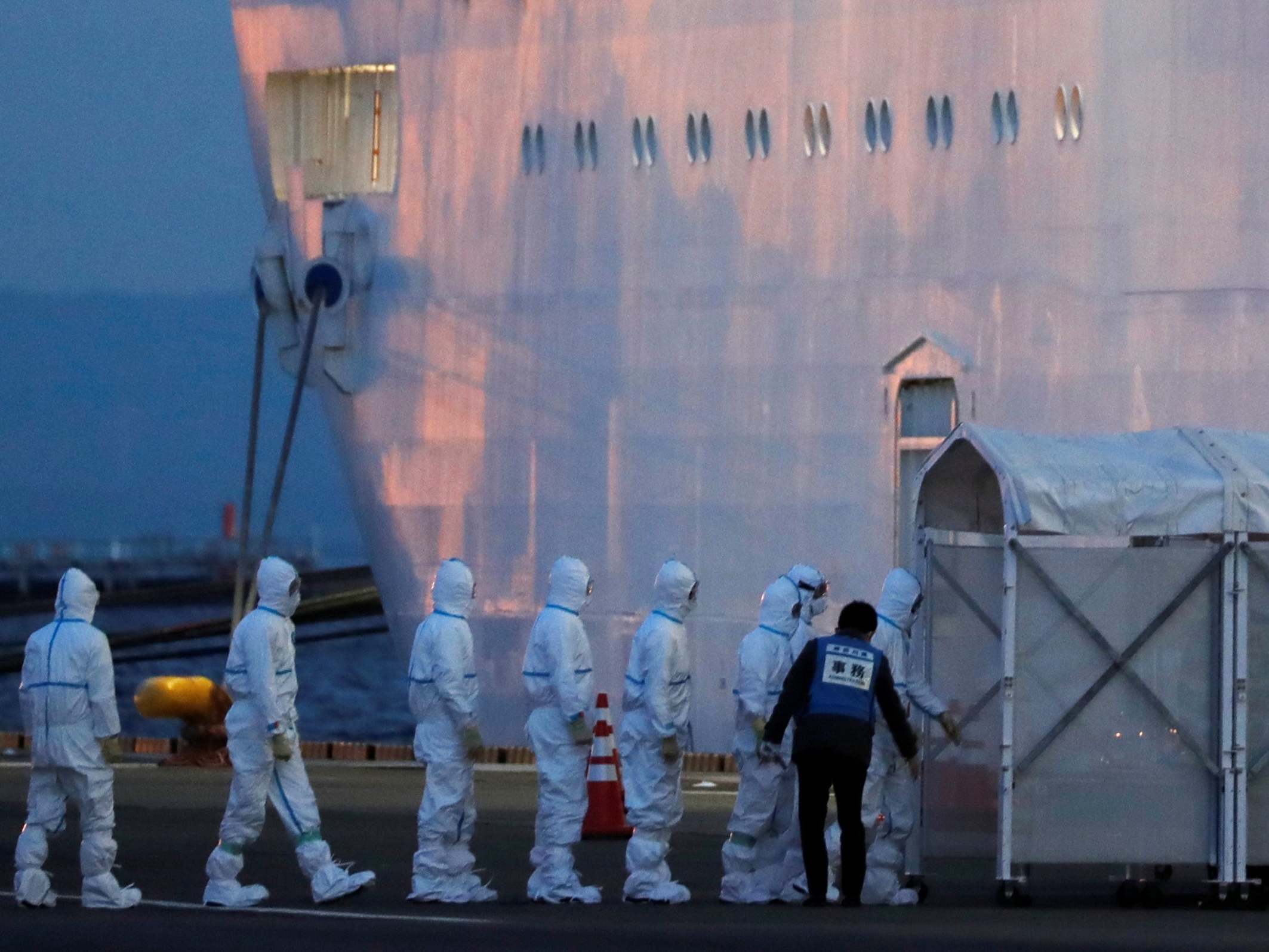 Officers in protective gear enter the cruise ship Diamond Princess after it arrives at in Yokohama, Japan, 7 February, 2020.