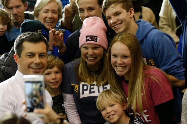 Pete Buttigieg poses for selfies with supporters while campaigning at Dover Middle School in New Hampshire