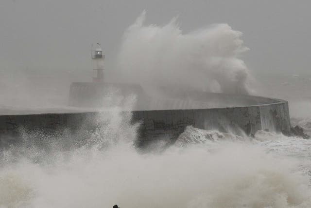 A man photographs large waves caused by Storm Ciara as they hit the the seafront and wall in Newhaven, East Sussex, 9 February, 2020.