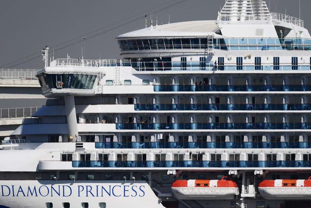 Passengers stand on balconies on the Diamond Princess cruise ship, which has been quarantined over the coronavirus outbreak