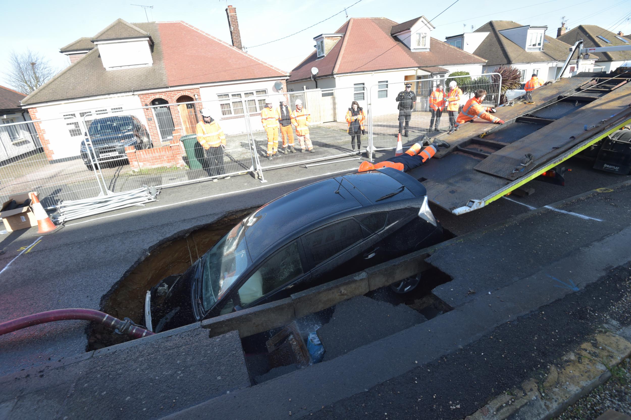 A car is removed from a sinkhole in Brentwood, Essex.