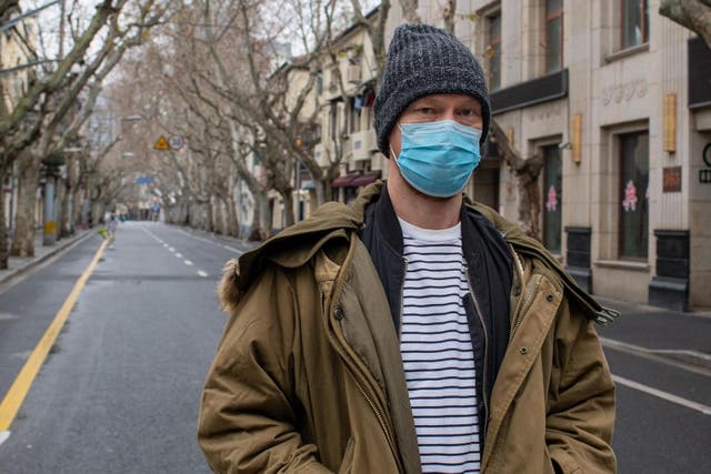 Photographer Dave Tacon, 43, wears a surgical mask on Xiangyang Road in the former French Concession. Shanghai is eerily empty as people stay indoors to avoid contagion from the coronavirus