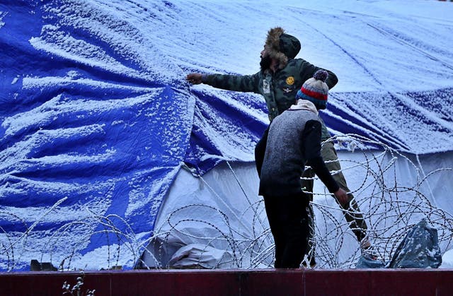 Protesters shake the snow off their tent in Tahrir Square in Baghdad, Iraq, Tuesday, Feb. 11, 2020.