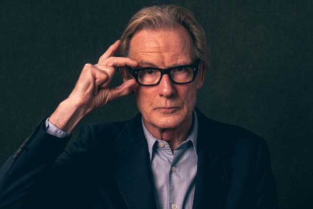 In a well-fitting navy suit and black specs, Nighy is still the suave heartthrob he always was
