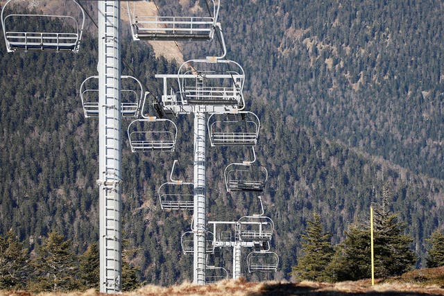 Chairlifts run over ski slopes closed due to lack of snow at The Mourtis resort