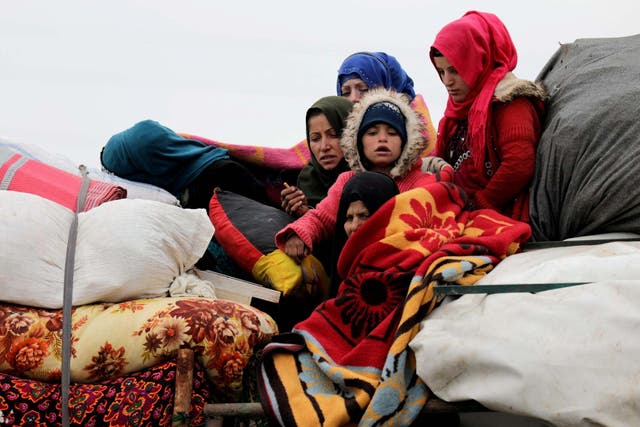 Internally displaced Syrians from western Aleppo countryside, ride on a vehicle with belongings in Hazano near Idlib, Syria, February 11, 2020.
