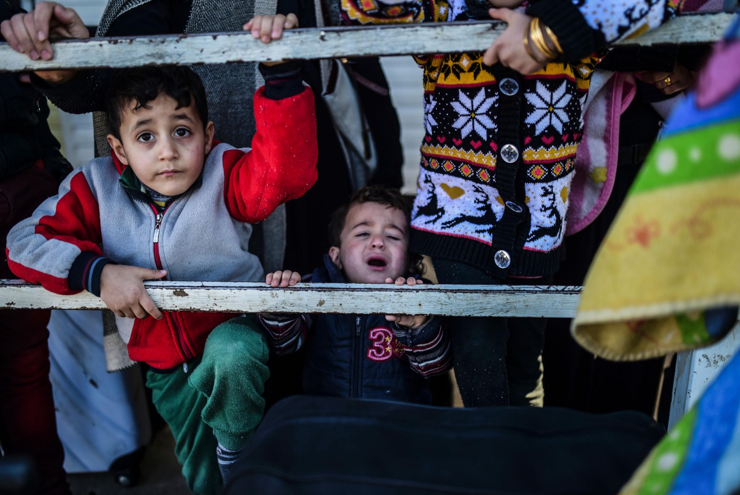 Syrian families wait at the Turkish Oncupinar border gate near Kilis, south-central Turkey