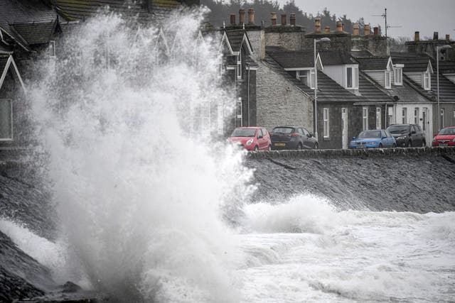 Waves crash against the harbour wall in Port William