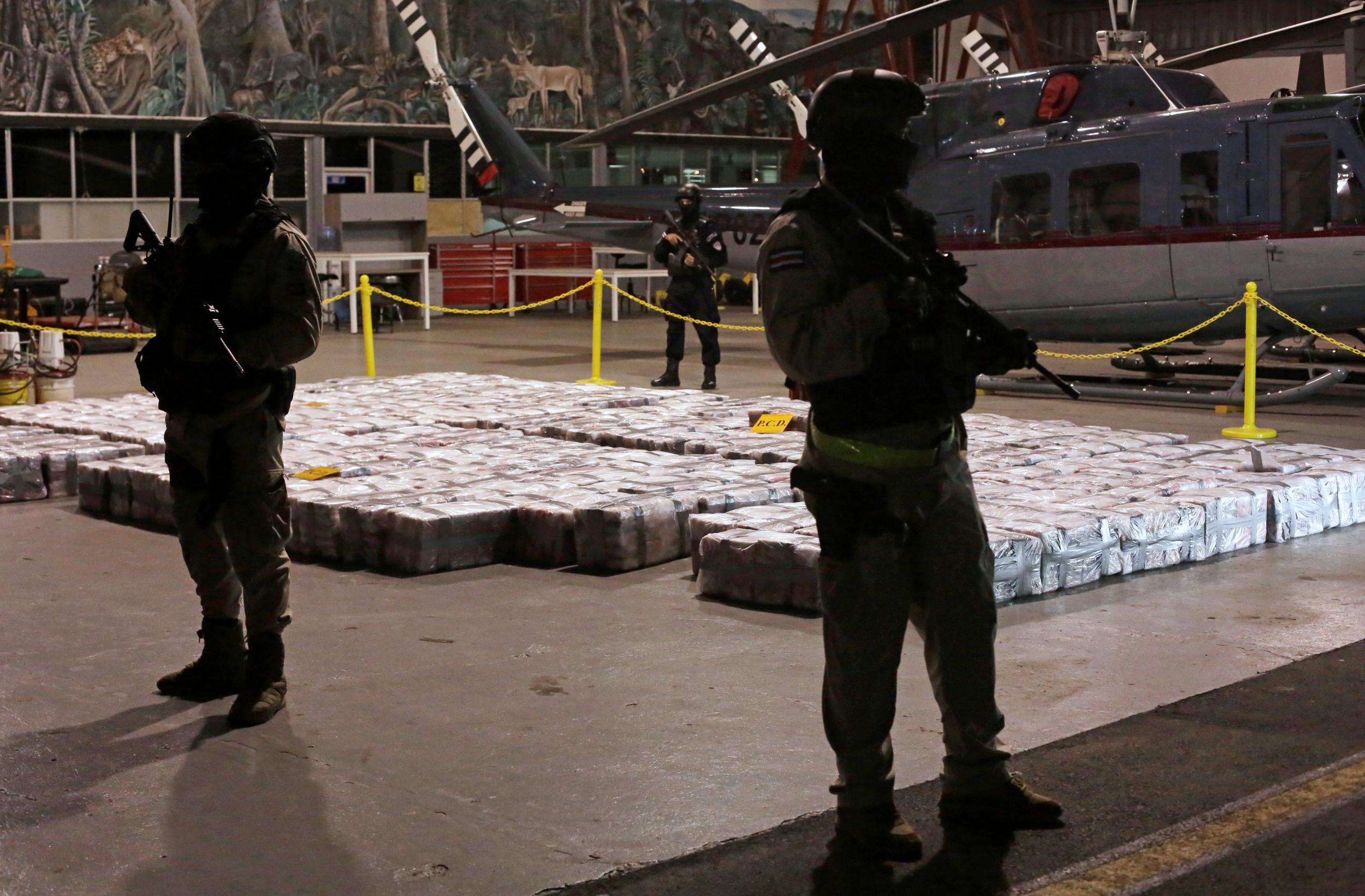 Costa Rican police officers are seen on Saturday February 15, 2020, in front of packages containing cocaine seized during an operation in the Caribbean.