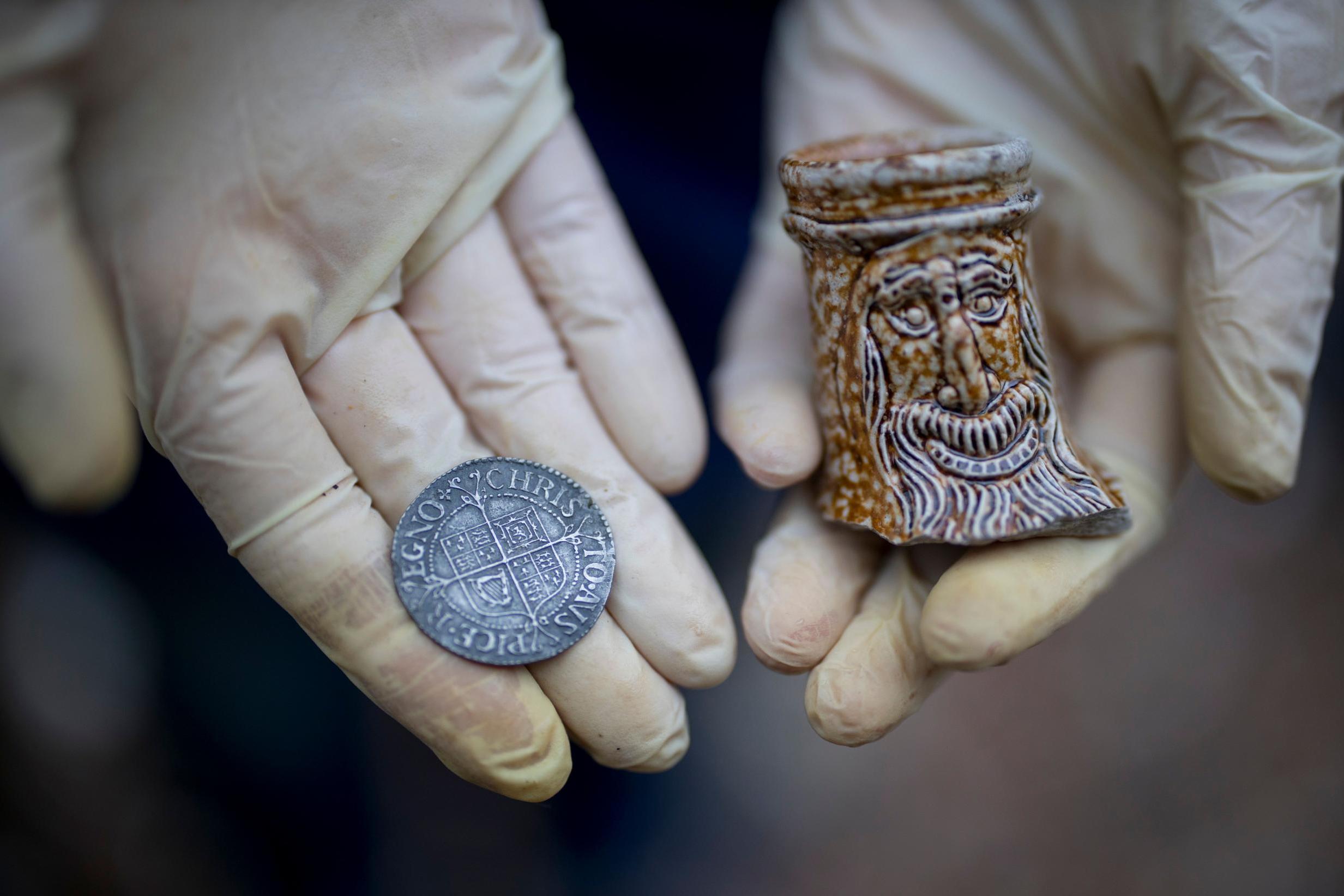 A 17th-century coin and part of a Bellarmine jug are just some of the day’s finds (AFP/Getty)