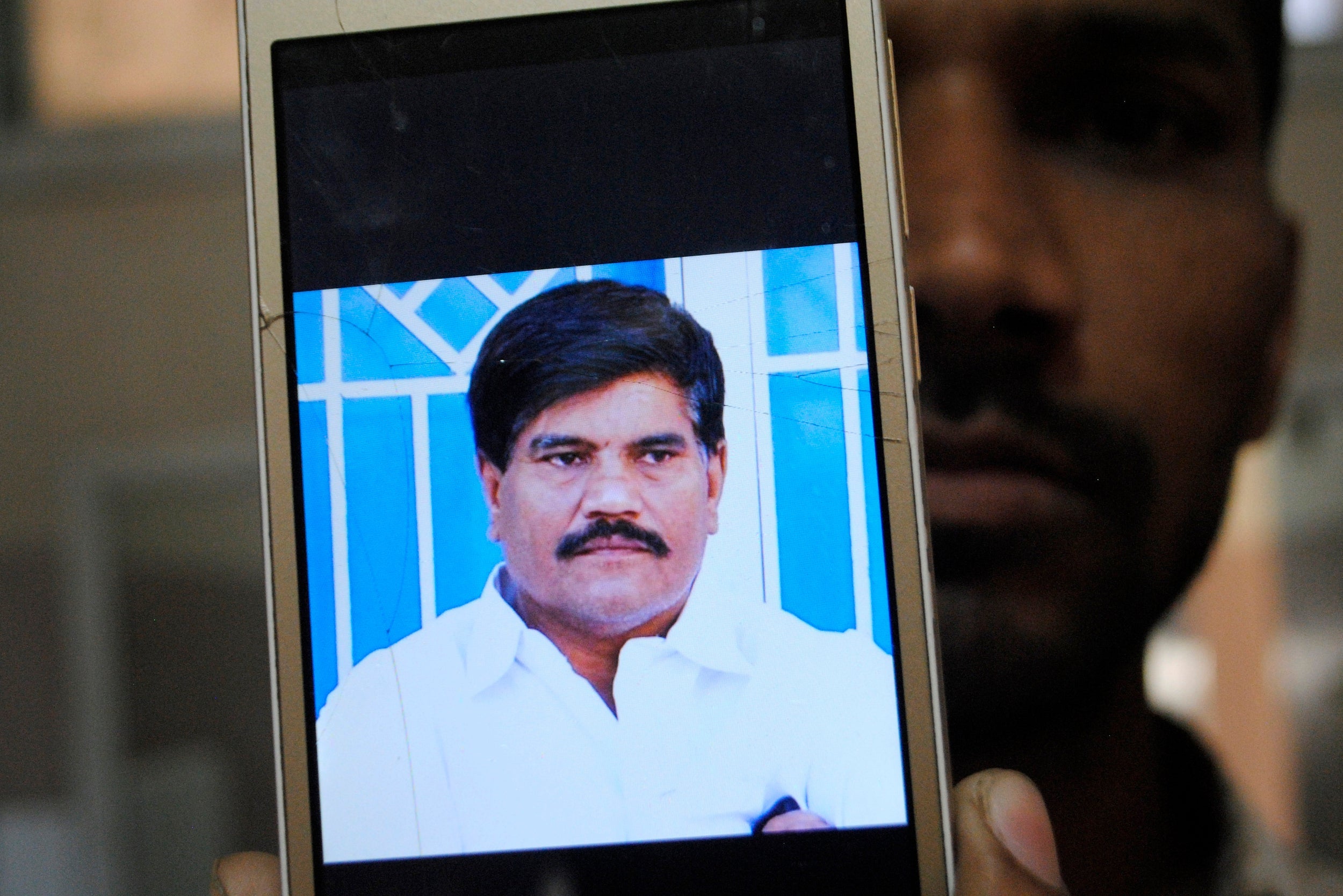 An employee of a local television channel shows a picture of slain journalist Aziz Memon, in Hyderabad, Pakistan