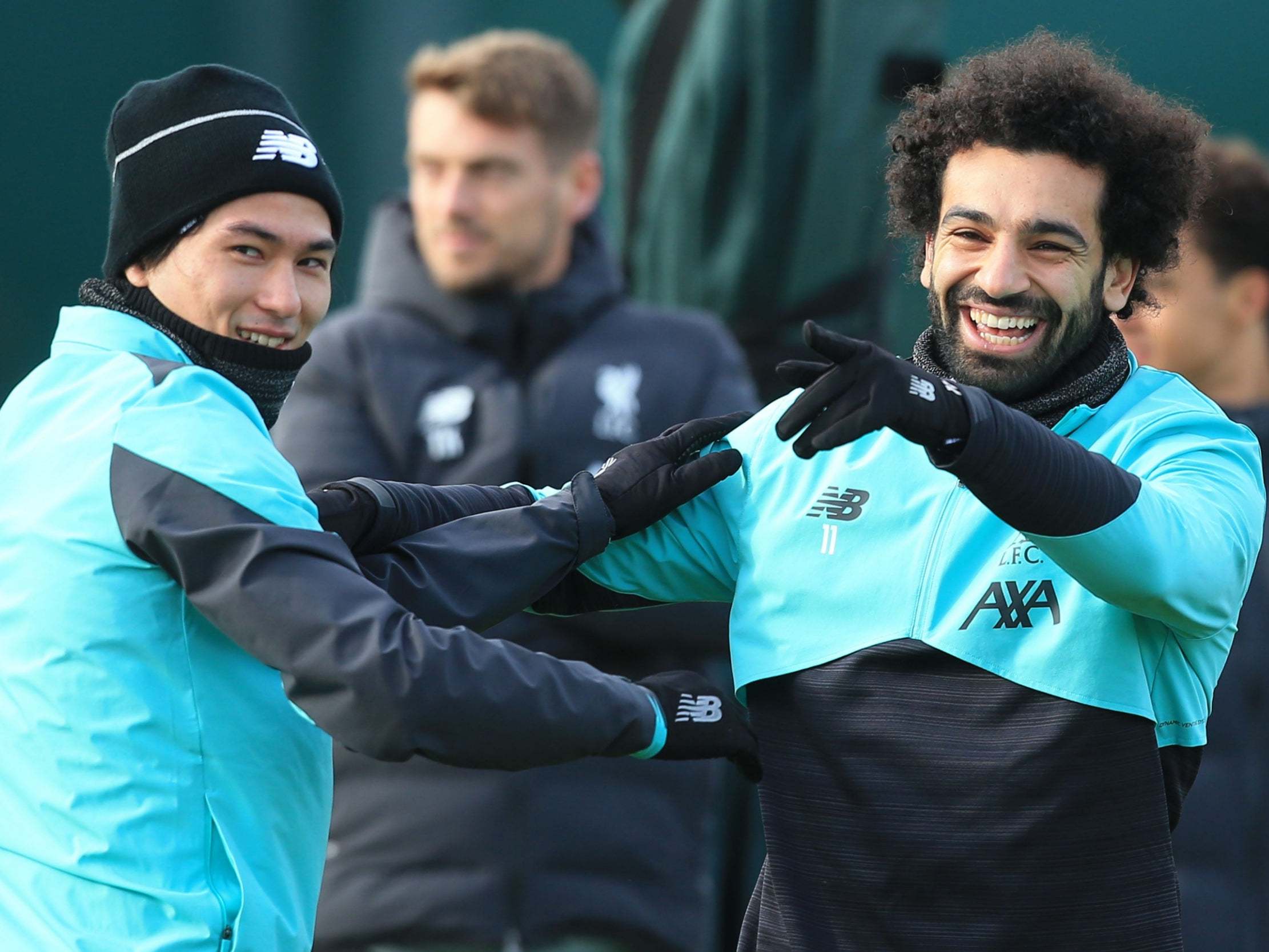 Liverpool's Mohamed Salah jokes with Takumi Minamino