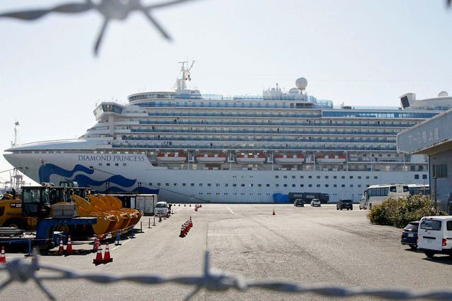 The quarantined ship Diamond Princess is pictured through barbed wire at Yokohama port in Yokohama, near Tokyo