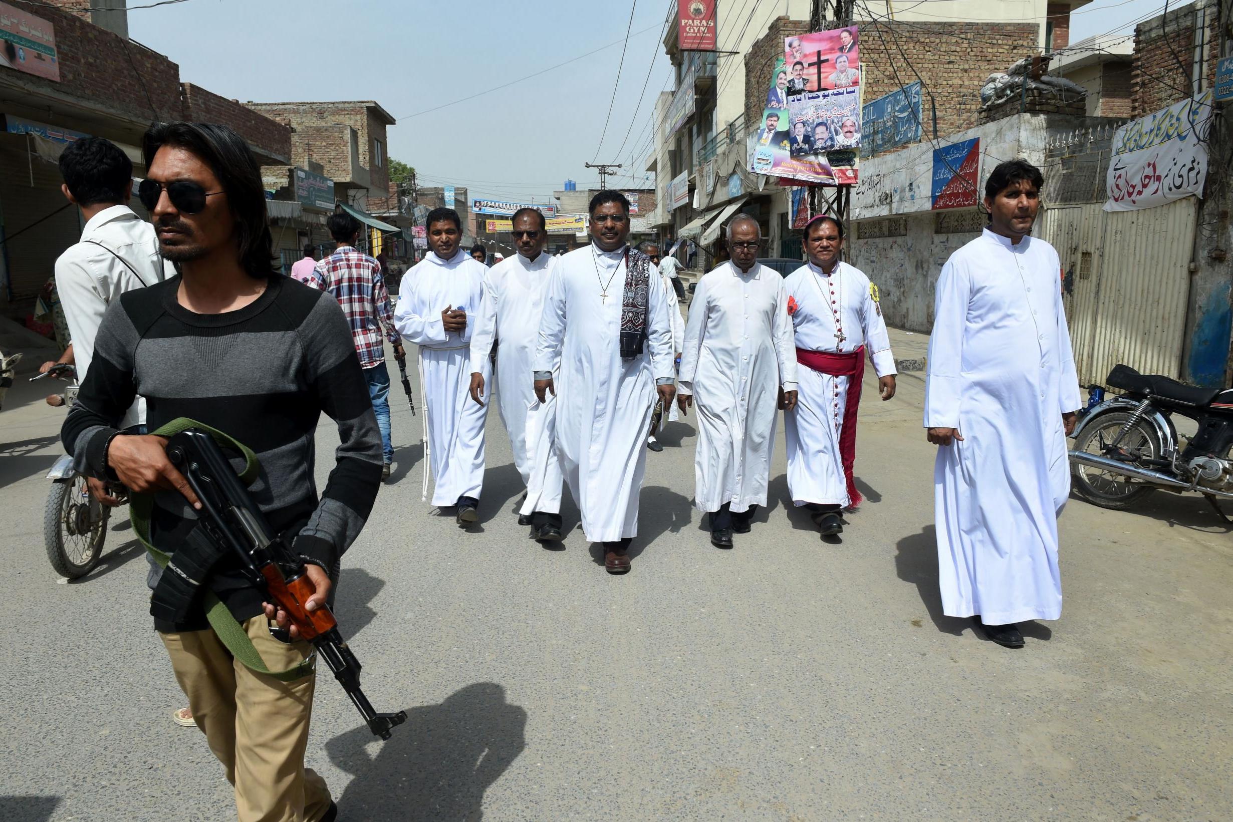 Private security guards escort Christian priests in Youhanabad, the most densely populated Christian neighbourhood in the country (AFP/Getty)