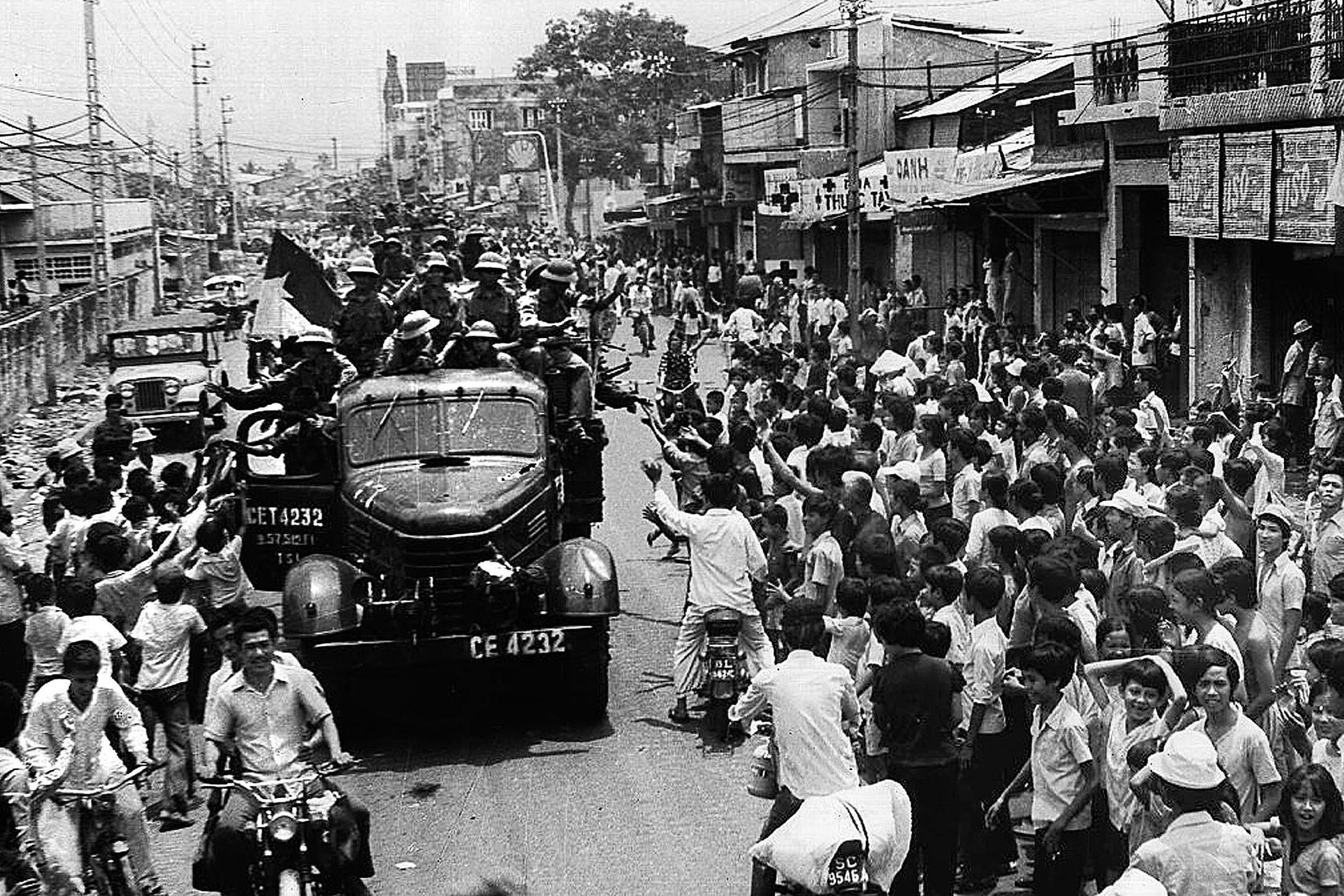 Saigon residents take to the streets to welcome the arrival of communist troops after the fall of the city