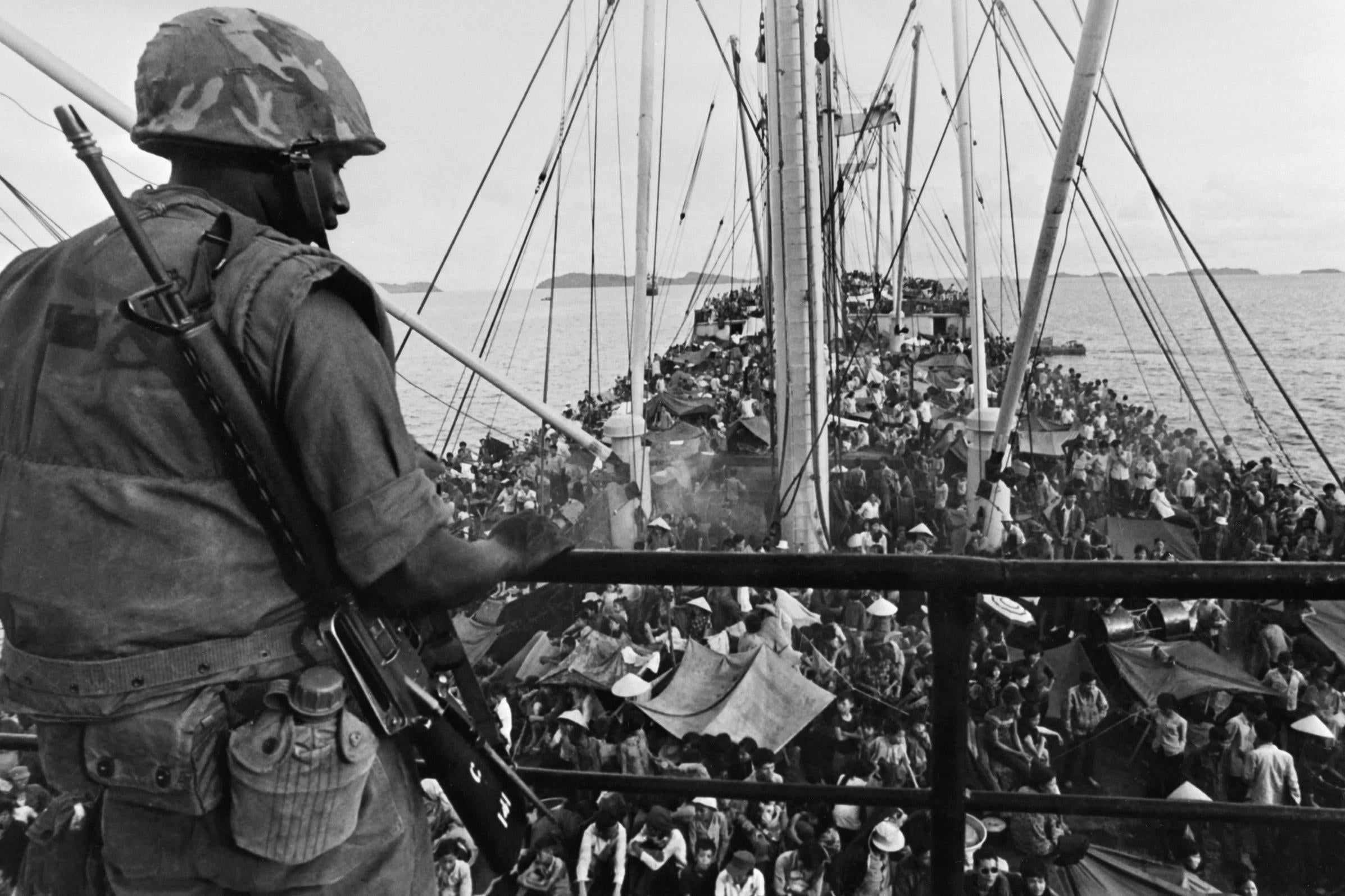 South Vietnamese crowd a US navy boat off the coast of the southeast Asian country