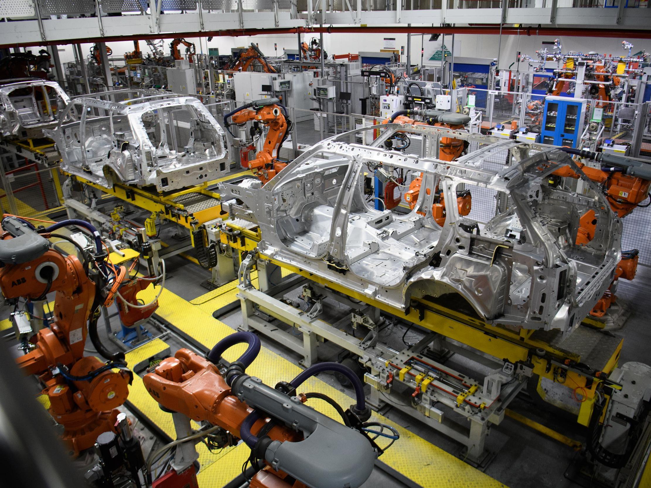 Robotic systems work on the chassis of a car during an automated stage of production at the Jaguar Land Rover factory