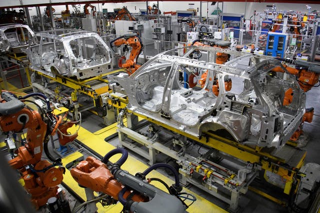 Robotic systems work on the chassis of a car during an automated stage of production at the Jaguar Land Rover factory
