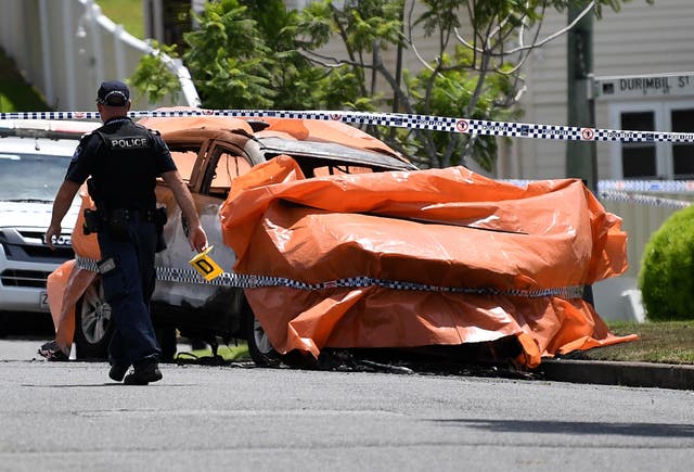 Police work at the scene of a car fire in Brisbane, Australia, where four people died, including three young children, and a woman suffered extensive injuries
