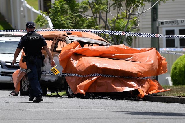 Police work at the scene of a car fire in Brisbane, Australia, where four people died, including three young children, and a woman suffered extensive injuries